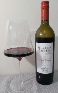 Hester Creek Cabernet Merlot 2022 with wine in glass