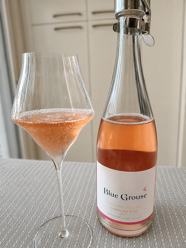 Blue Grouse Estate Winery Charme de l'ile Sparkling Rose Brut with wine in glass